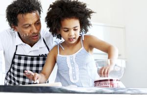 Father and daughter together baking