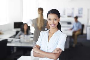 An attractive ethnic business woman smiling confidently at the camera as she stands in an office