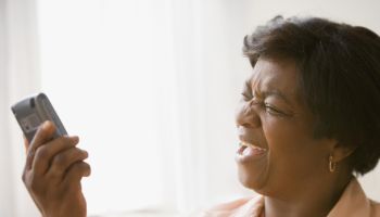 Senior African woman yelling at cell phone