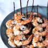 Grilled shrimp skewered with rosemary twigs on stoneware platter