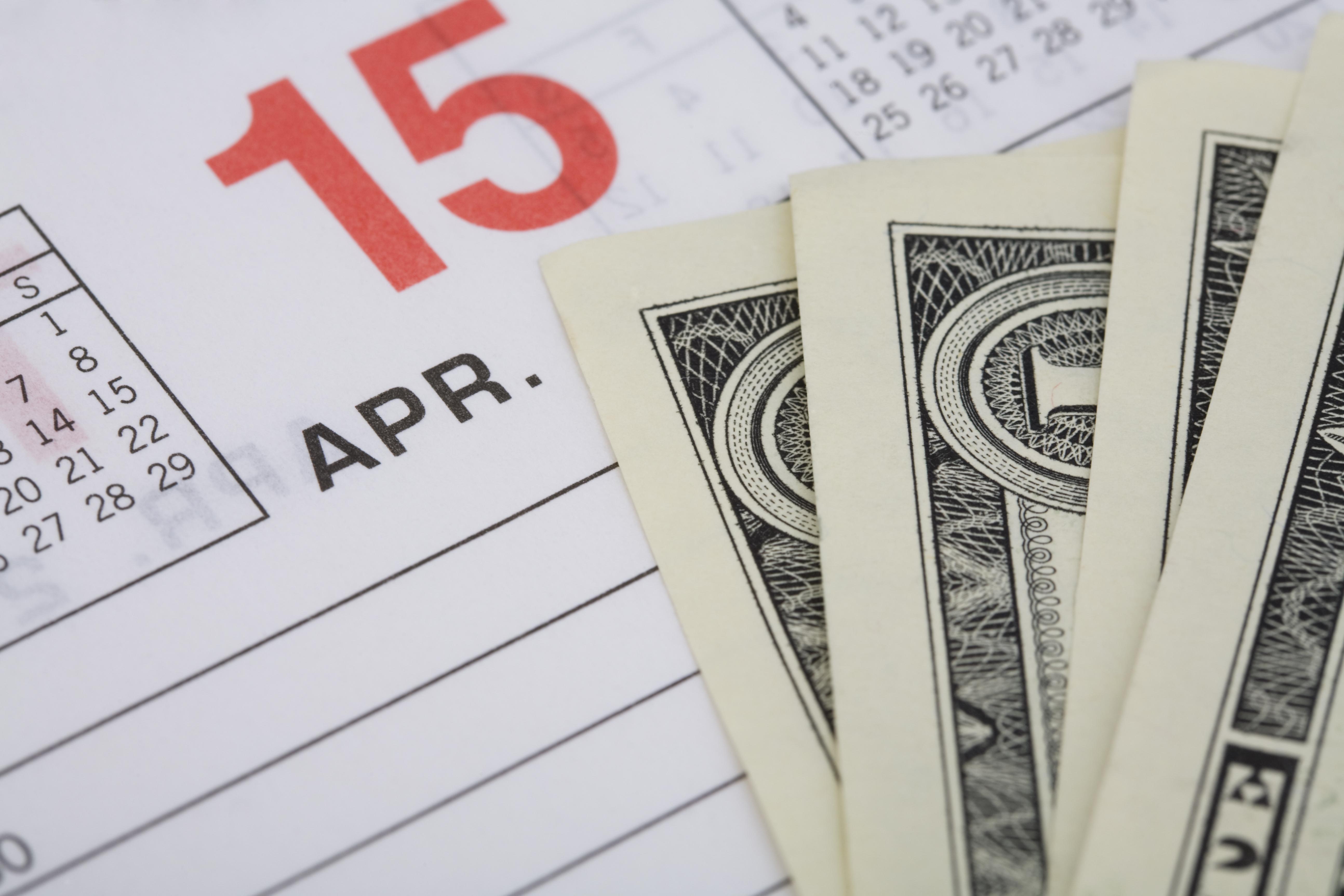 Dollar bills on an April 15th calendar page