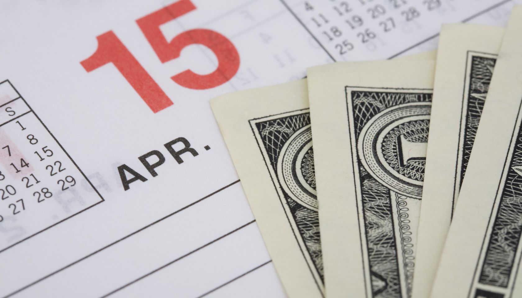 Dollar bills on an April 15th calendar page
