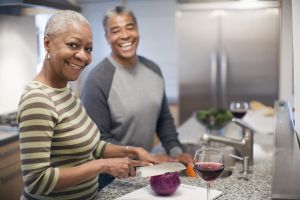 Laughing couple preparing dinner