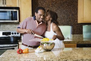 African couple fixing healthy meal in modern kitchen