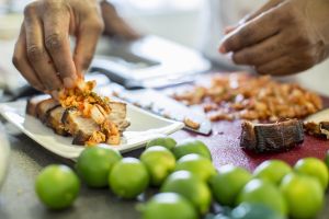 Black chef making pork belly and kimchee in restaurant