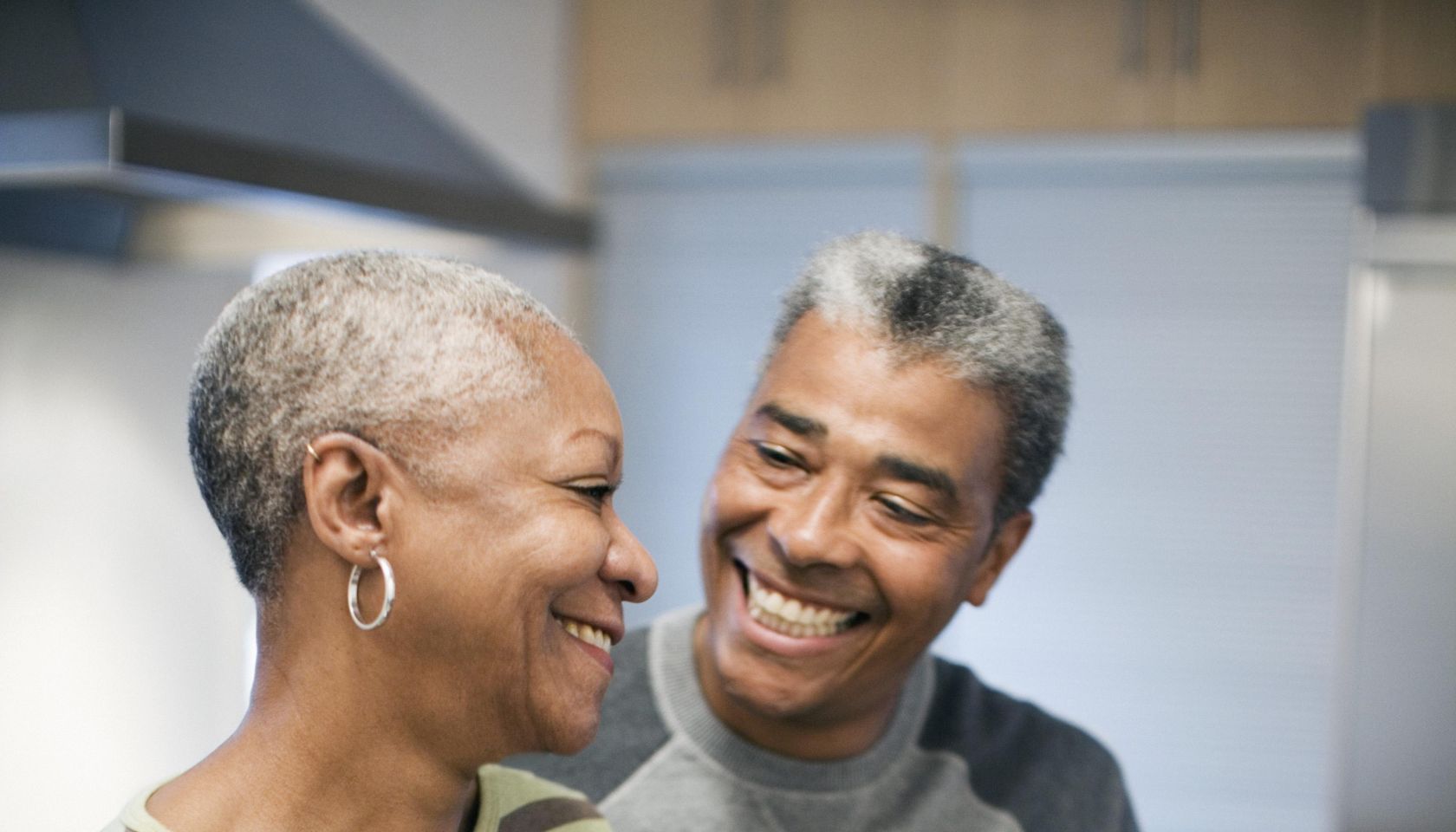 Couple laughing in kitchen together