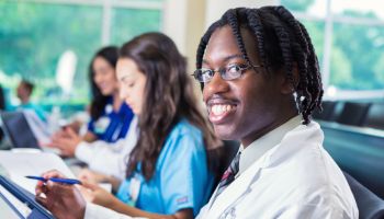 Young male nursing student smiling during medical college class