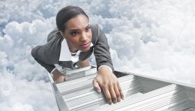 African American businesswoman climbing ladder