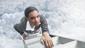 African American businesswoman climbing ladder