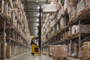 Warehouse worker lifting a pallet of boxes