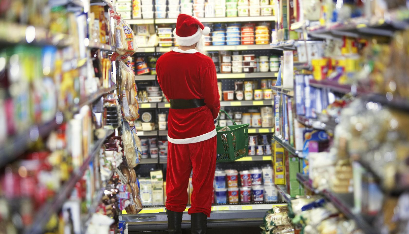Man dressed as Santa Claus standing in supermarket, rear view