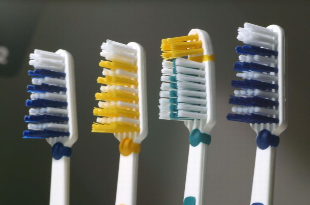 Four coloured toothbrushes.