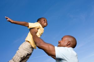 Father lifting son, son pretending to fly