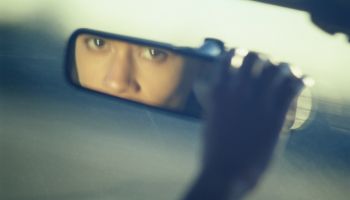 Woman Looking into a Rear-View Mirror