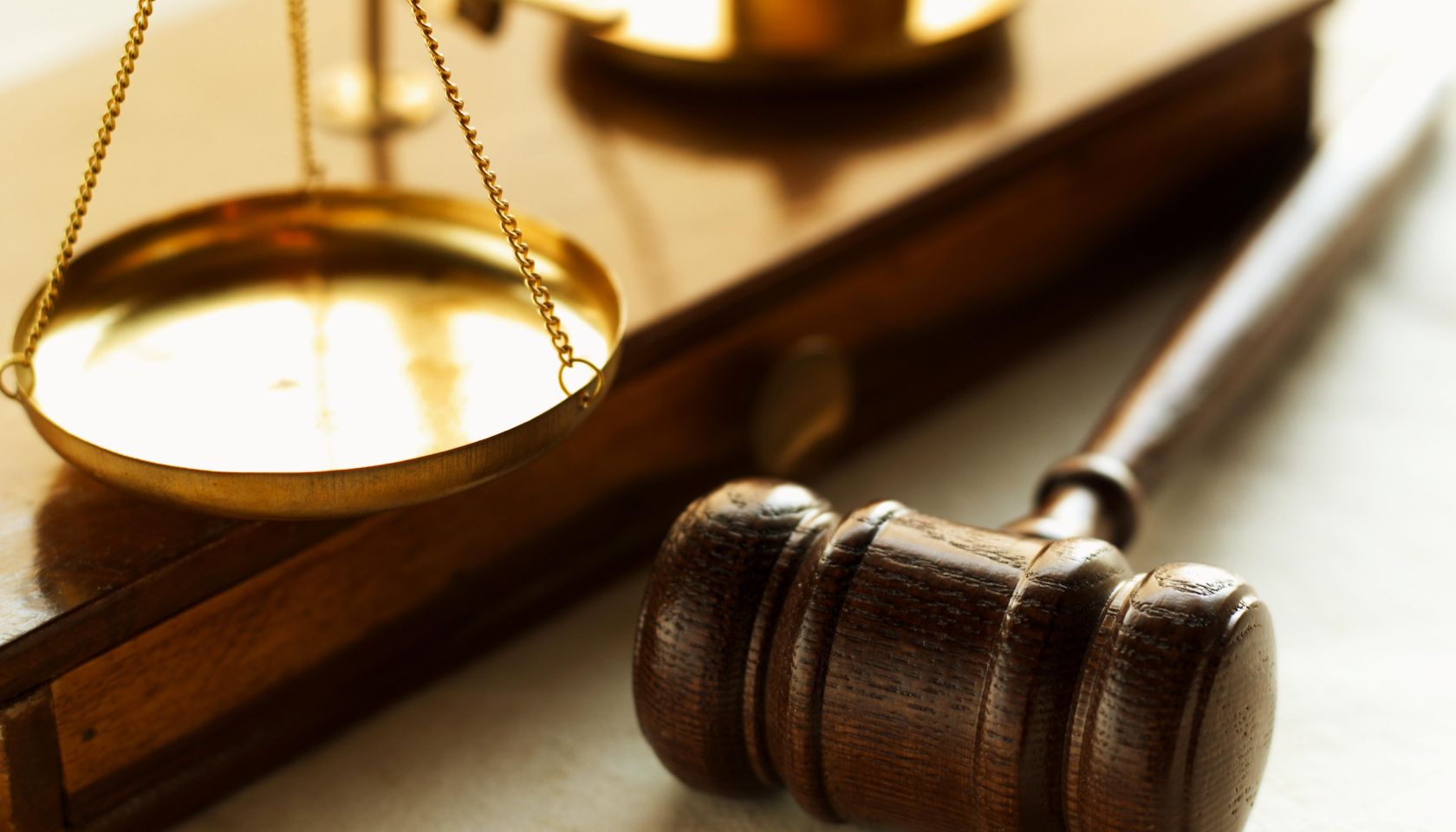 Close-up of weights balancing scales of justice with gavel beside it