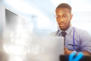 Junior doctor working at his desk in his office