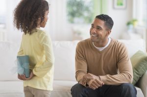 Daughter (6-7) hiding gift for her father behind her back