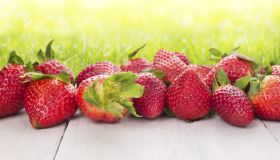 strawberries on white wooden table in sunny garden