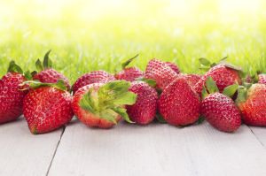 strawberries on white wooden table in sunny garden