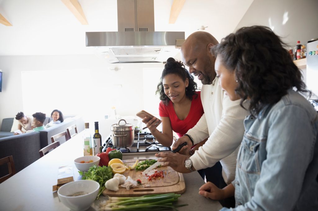 African American father and daughters cooking in kitchen