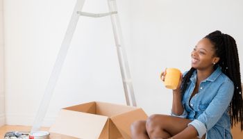 Black woman drinking coffee in new home