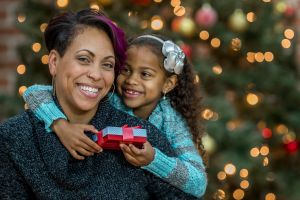 A mother and daughter are opening presents together