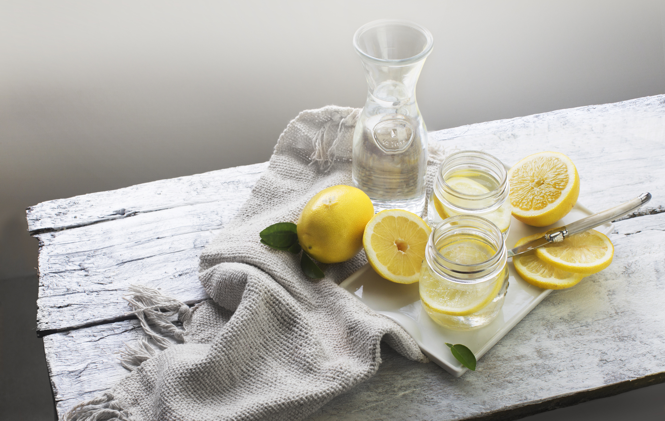 Lemon water on white wooden table. Still life.