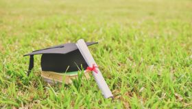 Mortarboard And Diploma On Field