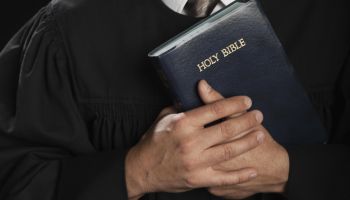 Hispanic pastor holding Bible