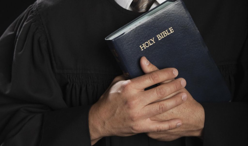 Hispanic pastor holding Bible