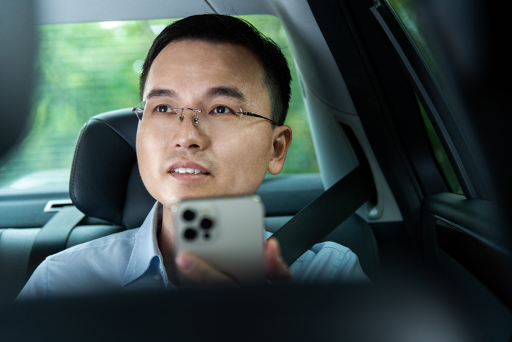 Man sitting on the back seat and using mobile phone