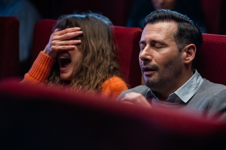 Mid Adult Caucasian Couple Experiencing Intense Horror Film in Cinema