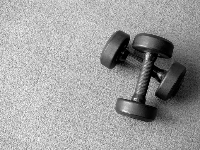 Black dumbbells on carpet floor in minimal setting, representing home workout, personal training, and healthy lifestyle. Ideal for fitness content, wellness blogs, and indoor exercise themes.