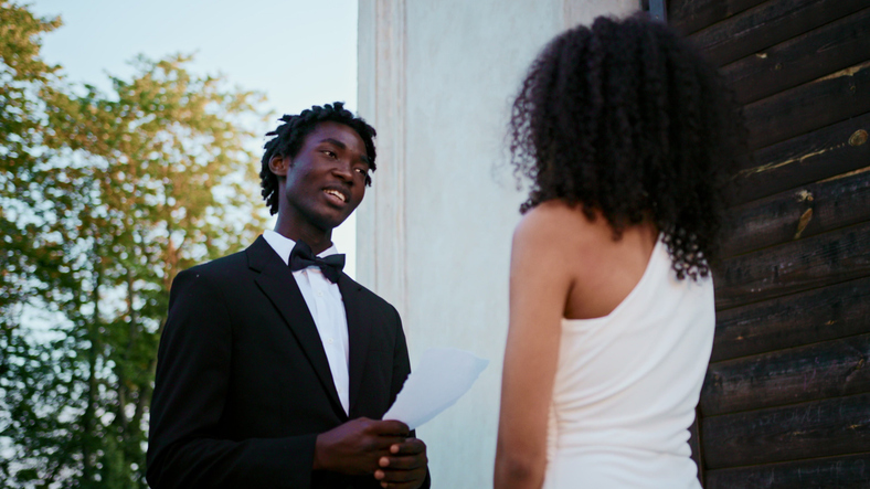 The groom reads the wedding vow looking at.