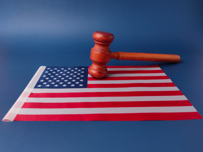 Wooden gavel resting on a folded United States flag
