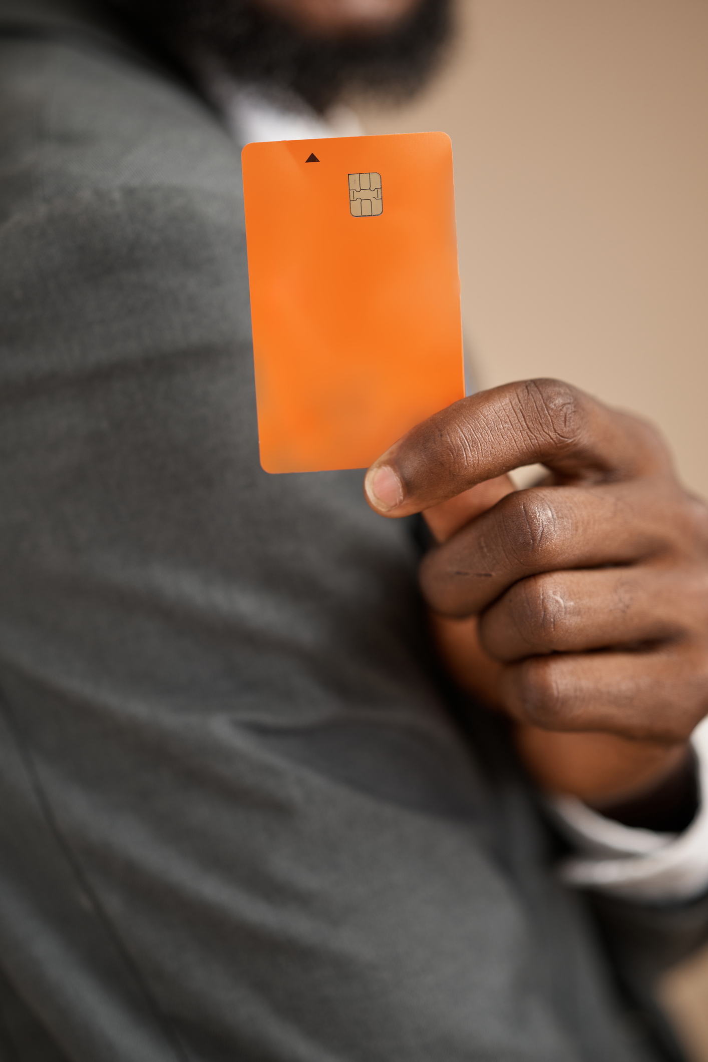 Businessman Holding Orange Debit Card Close-Up For Payment And Banking Financial Concept