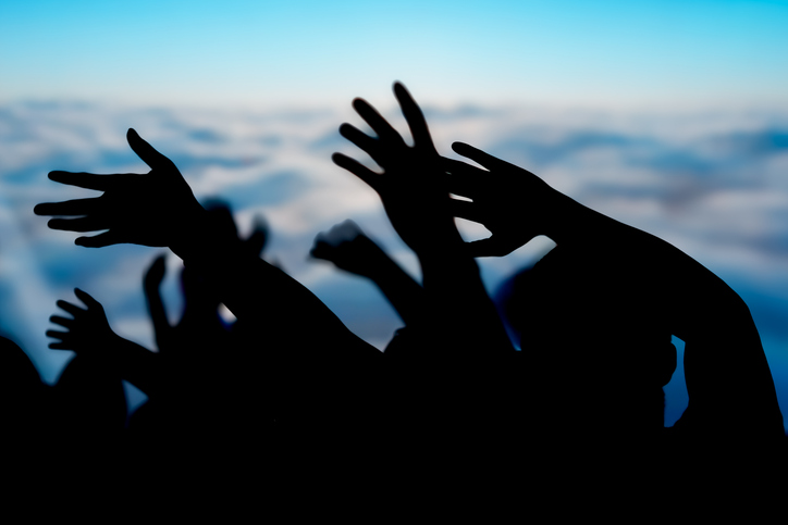 Silhouette Waving Hands in the air ballroom, blurred background