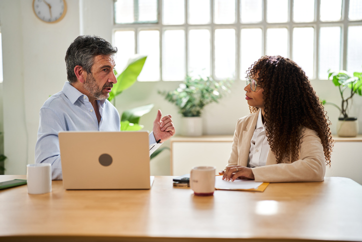 Business professionals collaborating at office meeting with laptop