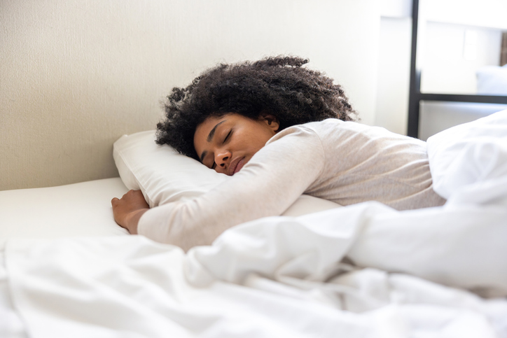 Woman sleeping in a white bed