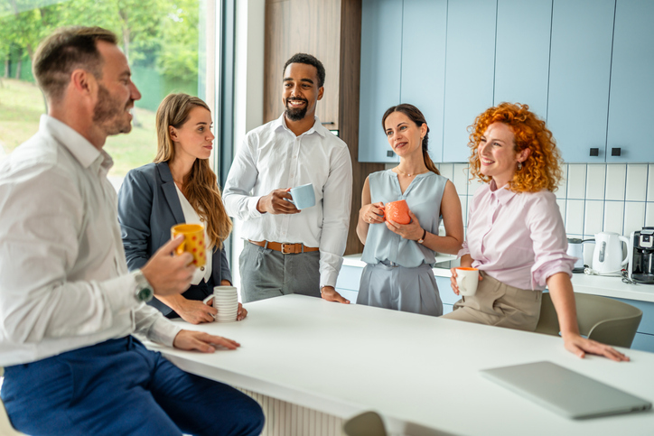 Diverse business team networking during coffee break in office kitchen