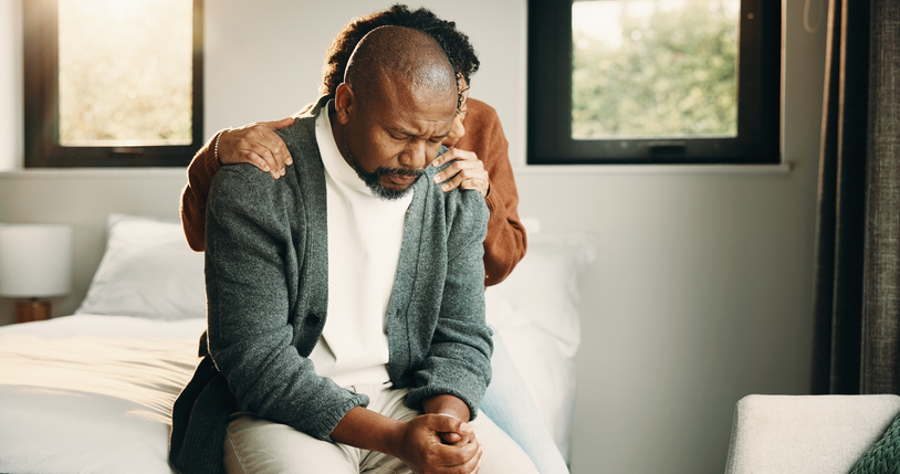 Sad, couple and comfort with hug at house for empathy, grieving partner and emotional support. African people, embrace and consoling for grief, mourning loss and understanding heartbreak in bedroom