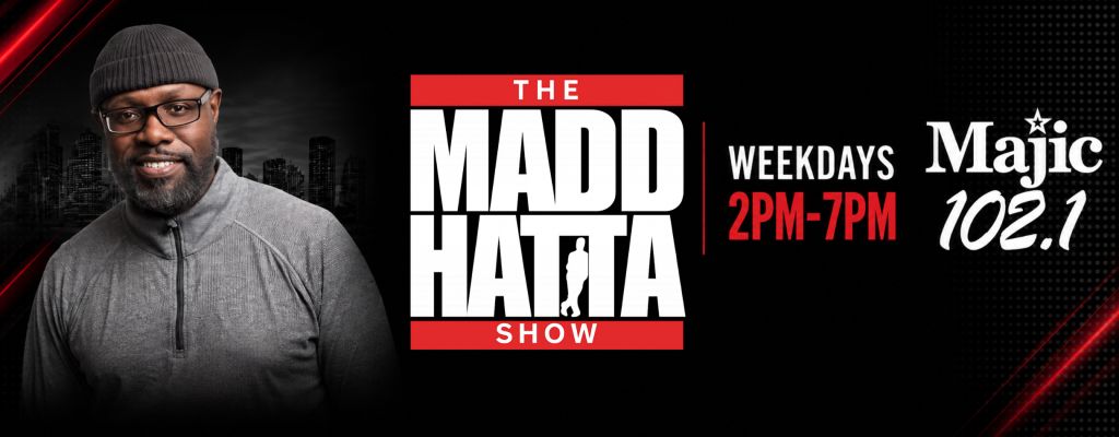 A smiling man wearing glasses and a gray hat appears in front of a cityscape backdrop, with text promoting "The Madd Hatta Show" on Majic 102.1 radio.