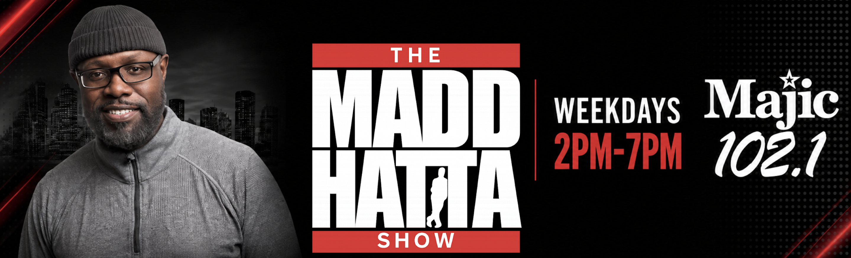 A smiling man with a beard wearing glasses and a gray hooded jacket, standing in front of a city skyline. The text "THE MADD HATTA SHOW" and "WEEKDAYS 2PM-7PM Majic 102.1" is displayed.